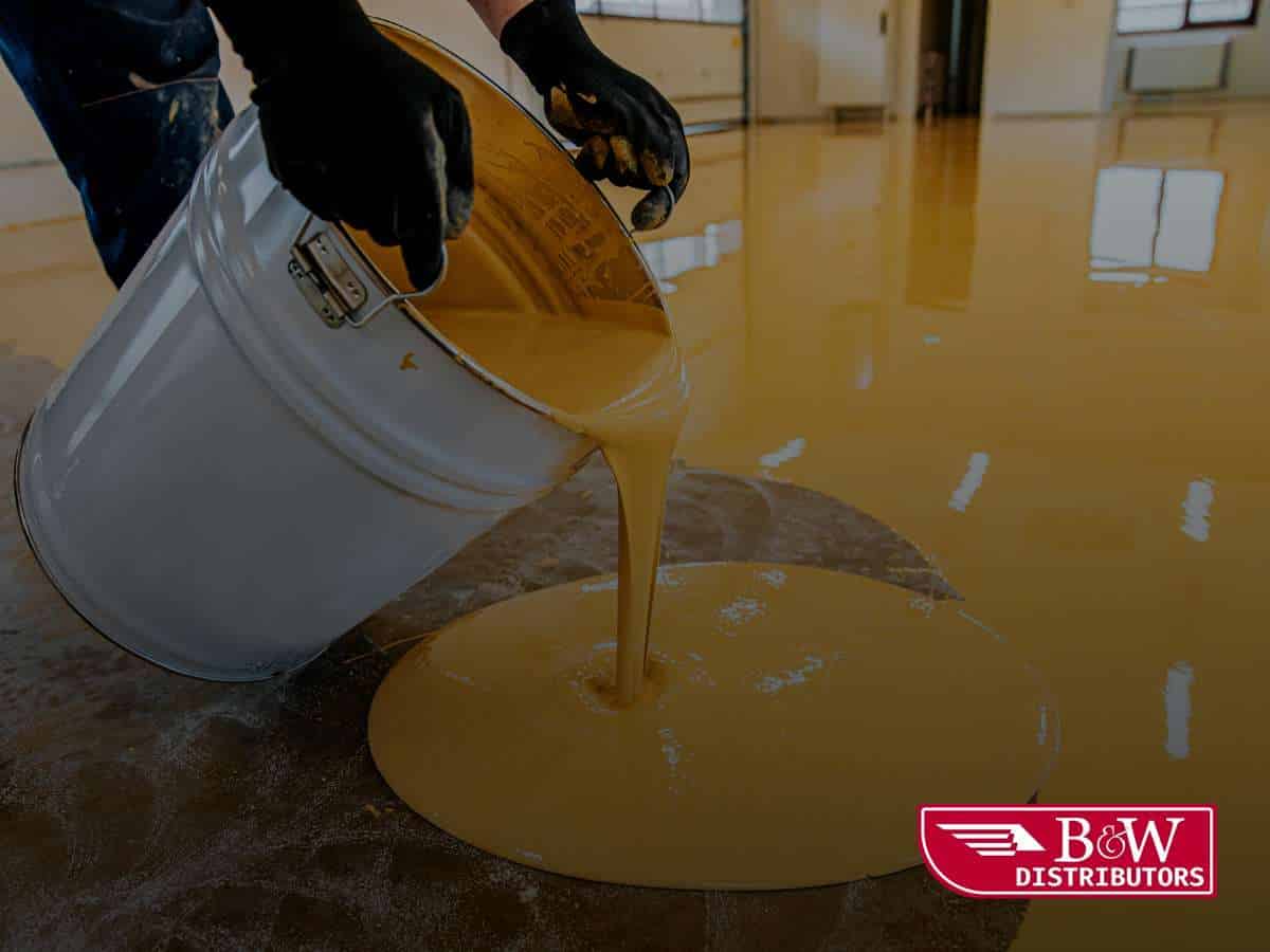 Worker pouring Epoxy Concrete Floor Paint onto a surface for a smooth, durable finish